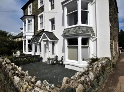 a white house with a stone retaining wall at 4 Bed in Keswick oc-87567 in Keswick