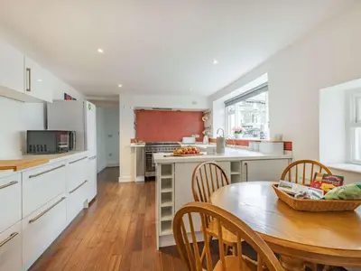 a kitchen with a wooden table and a dining room at 4 Bed in Keswick oc-87567 in Keswick