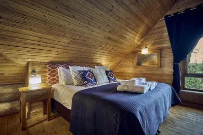 a bedroom with a bed in a log cabin at Alder Lodge with Hot-tub in Carlisle