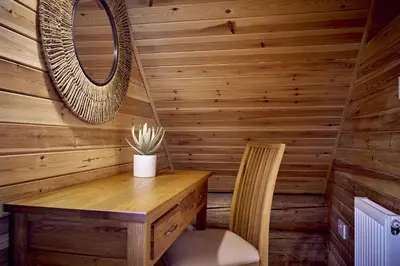 a wooden cabin with a table and a chair at Alder Lodge with Hot-tub in Carlisle