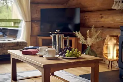 a wooden coffee table with a bowl of fruit on it at Alder Lodge with Hot-tub in Carlisle