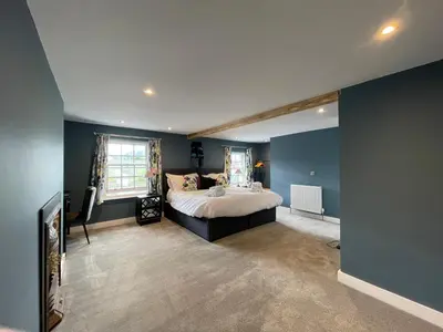 a bedroom with blue walls and a large bed at The Ship Inn's Mill Cottage - Weavers Way in Gatehouse of Fleet