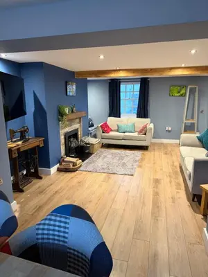 a living room with a couch and a fireplace at The Ship Inn's Mill Cottage - Weavers Way in Gatehouse of Fleet