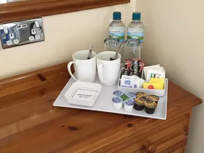 a tray with two cups and drinks on a counter at Cubbon House in Douglas