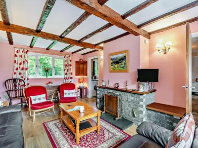 a living room with a fireplace and red chairs at 3 Bed in Threlkeld SZ047 in Threlkeld