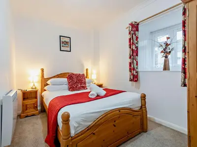 a bedroom with a wooden bed with a red blanket at 1 Bed in Rosthwaite 86395 in Rosthwaite