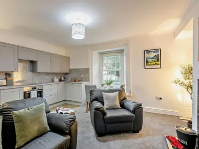 a living room with two couches and a kitchen at 1 Bed in Rosthwaite 86395 in Rosthwaite