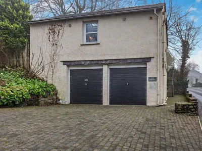 a house with two garage doors and a window at 1 Bed in Keswick SZ516 in Keswick