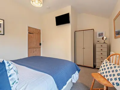 a bedroom with a bed and a tv on the wall at 2 Bed in Keswick oc-sz006 in Keswick