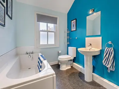 a blue bathroom with a tub sink and a toilet at 2 Bed in Keswick oc-sz006 in Keswick