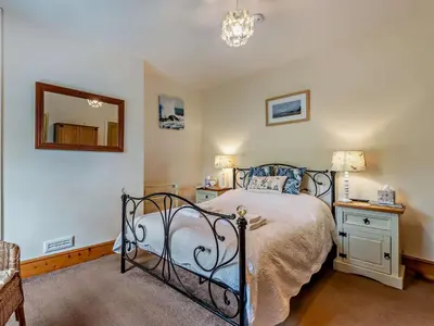 a bedroom with a bed and a mirror on the wall at 3 Bed in Ullock SZ043 in Arlecdon