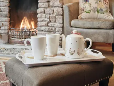 a tray with two cups on a table with a fireplace at 3 Bed in Ullock SZ043 in Arlecdon