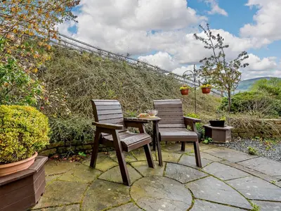two chairs and a table on a patio at 1 Bed in Troutbeck SZ254 in Troutbeck