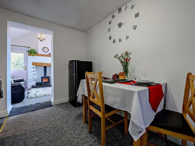 a dining room with a table and chairs and a fireplace at 1 Bed in Troutbeck SZ254 in Troutbeck