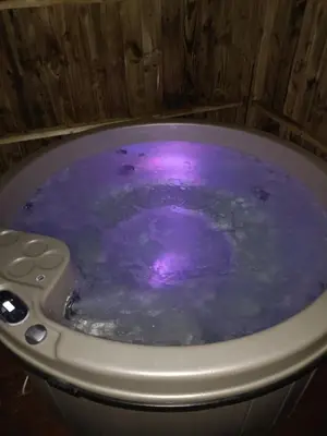 a bath tub filled with purple water in a room at Hillingworth's Hot Tub Retreat - Lochmaben in Dumfries
