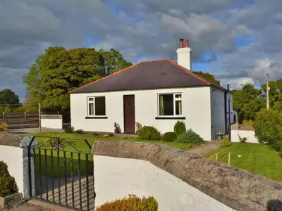 a white house with a fence in front of it at Criffel View in Dumfries