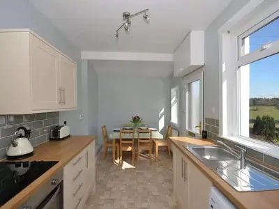 a kitchen with a table and a dining room at Criffel View in Dumfries