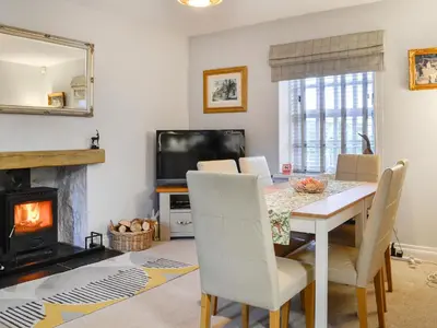 a dining room with a table and a fireplace at The Smithy in New Galloway