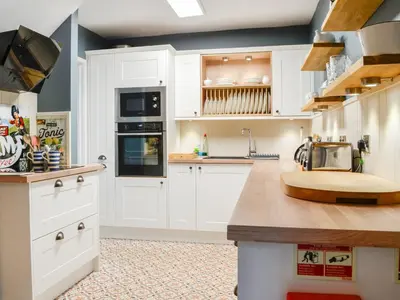 a kitchen with white cabinets and a counter top at The Smithy in New Galloway