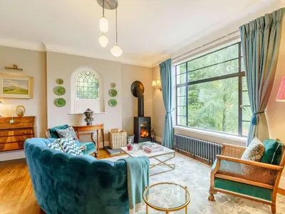a living room with a blue couch and a large window at 6 Bed in Keswick oc-89309 in Applethwaite
