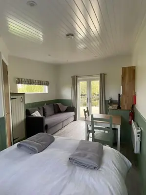 a bedroom with a bed and a living room at The Lily Pod in New Abbey