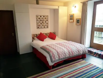 a bedroom with a bed with red pillows and a window at 3 Bed in Boot SZ502 in Eskdale