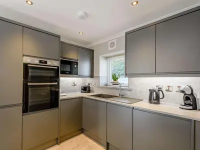 a kitchen with stainless steel appliances and gray cabinets at 1 Bed in Sandyhills 85904 in Fairgirth