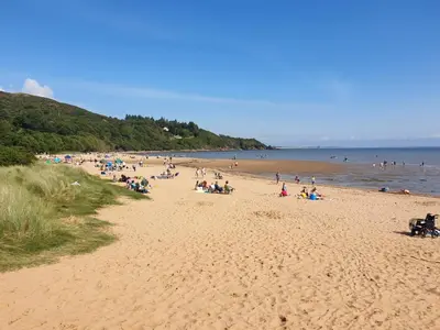 a group of people on a beach near the water at 1 Bed in Sandyhills 85904 in Fairgirth