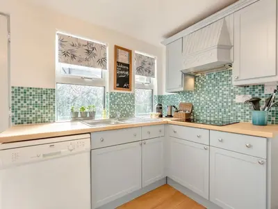 a kitchen with white cabinets and green tiles at 3 Bed in Keswick oc-89526 in Keswick