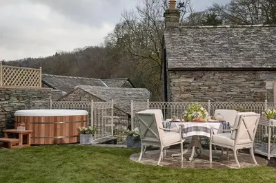a patio with a table and chairs and a barrel at The Little Cottage in Chapel Stile