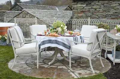 a table and chairs on a patio with food on it at The Little Cottage in Chapel Stile