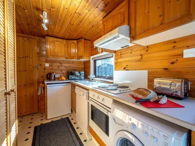 a kitchen with wooden cabinets and a stove top oven at 1 Bed in Keswick oc-82550 in Keswick