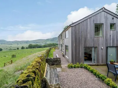 a wooden house on a hill with a bench at 3 Bed in Matterdale oc-83002 in Dockray