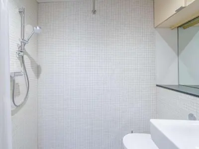 a white tiled bathroom with a shower and a sink at 3 Bed in Matterdale oc-83002 in Dockray
