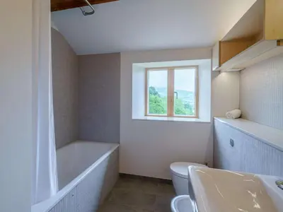 a bathroom with a tub and a toilet and a window at 3 Bed in Matterdale oc-83002 in Dockray