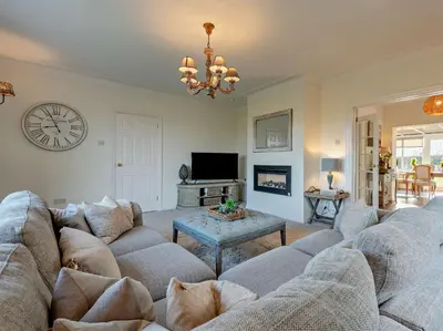 a living room with a couch and a clock on the wall at 3 Bed in Cockermouth 82438 in Dearham