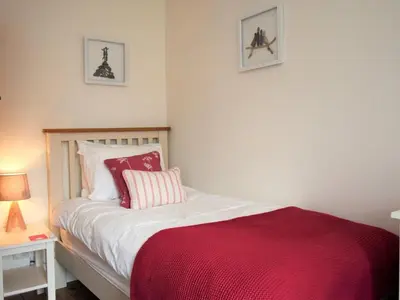 a bedroom with a bed with a red blanket at 3 Bed in Holmrook oc-sz313 in Boot