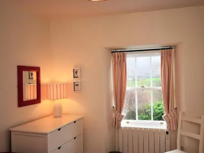 a bedroom with a window and a dresser with a lamp at 3 Bed in Holmrook oc-sz313 in Boot