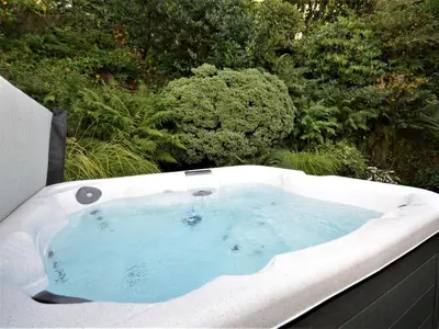 a bath tub with blue water in a garden at 3 Bed in Kippford 88274 in Kippford