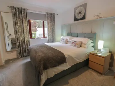 a bedroom with a large bed and a window at Hollys Hideaway in Castle Douglas