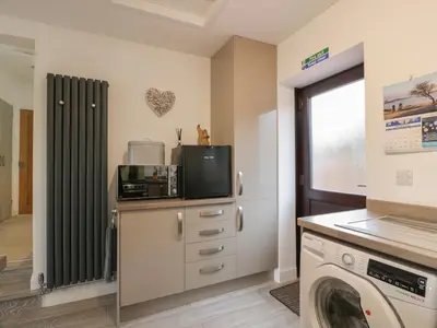 a laundry room with a washing machine and a washer at Hollys Hideaway in Castle Douglas