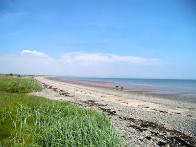 a bike parked on a sandy beach near the ocean at Craigielea Cottage in Newton Stewart