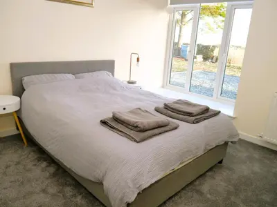 a bedroom with a large bed with towels on it at Craigielea Cottage in Newton Stewart