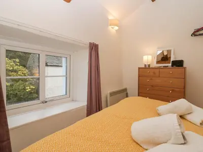 a bedroom with a bed and a window at Taylor's Cottage in Keswick
