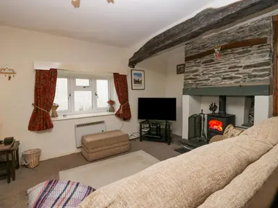 a living room with a couch and a fireplace at Taylor's Cottage in Keswick