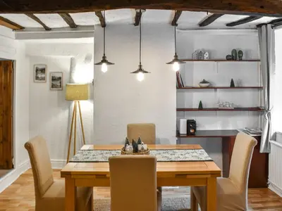 a dining room with a wooden table and chairs at Daffodil Cottage in Cockermouth