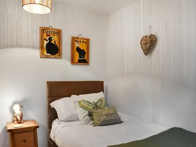 a bedroom with a bed and three pictures on the wall at Daffodil Cottage in Cockermouth