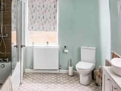 a bathroom with a toilet and a sink and a window at Daffodil Cottage in Cockermouth