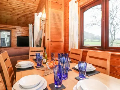 a dining room with a table with blue glasses on it at Latrigg Lodge in Keswick