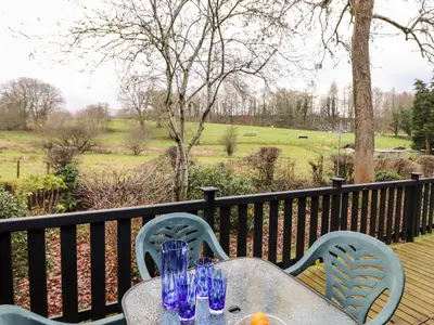 a table with blue glasses sitting on a deck at Latrigg Lodge in Keswick